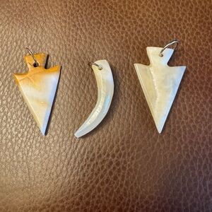 Trio of carved horn spearheads and horn pedants